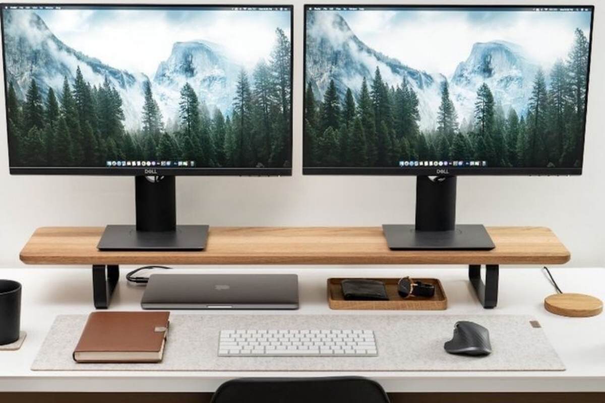 two office monitors on a riser