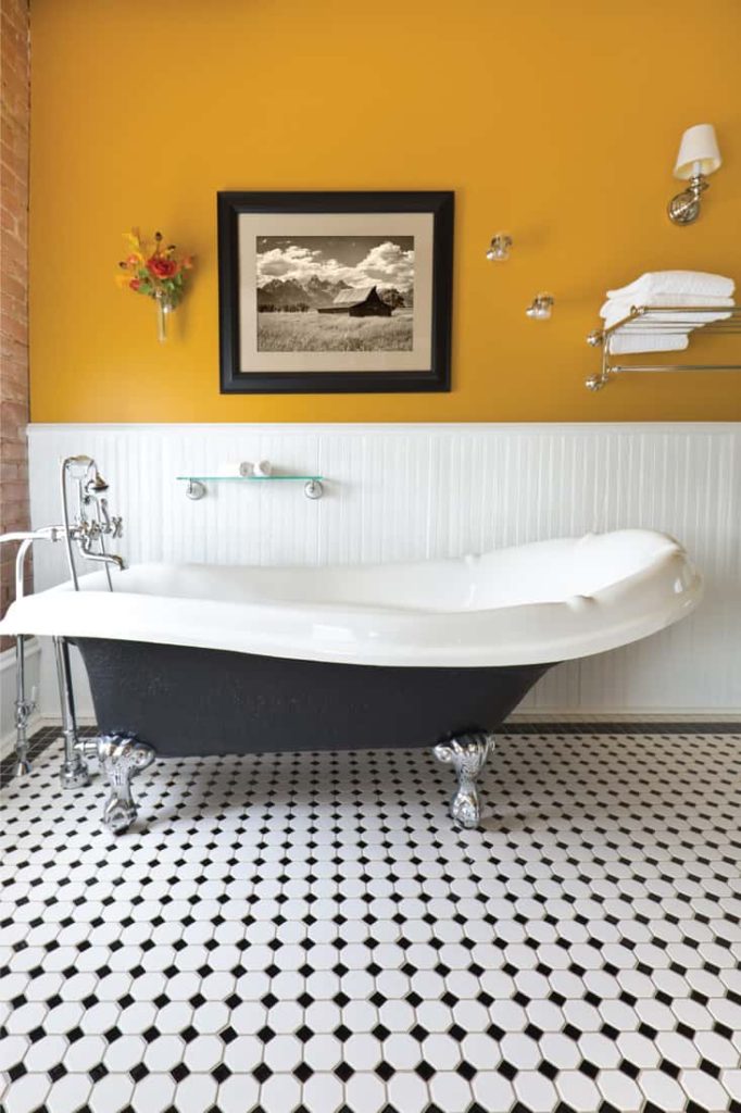 yellow walls bathroom with free standing bath