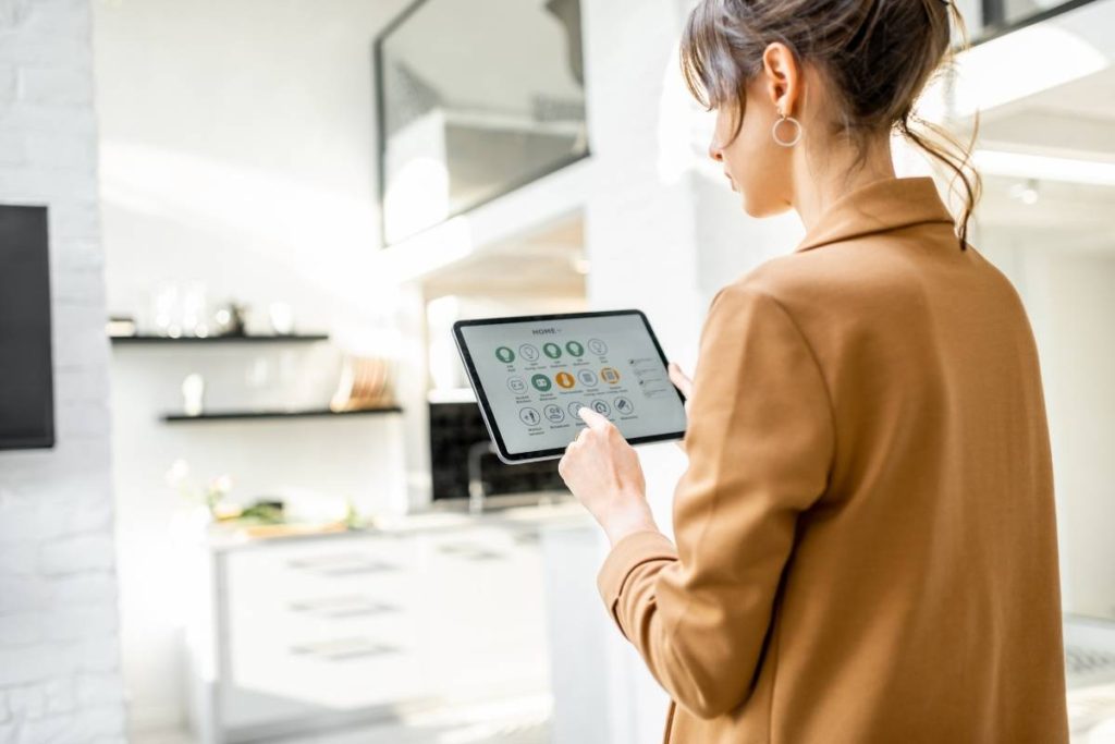 woman holds tablet with smart home app