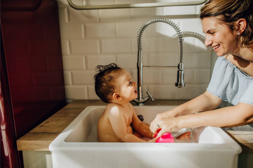 baby bathing in farmhouse sink